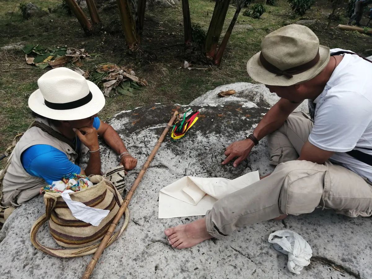 Guías registrando una piedra con petroglifos